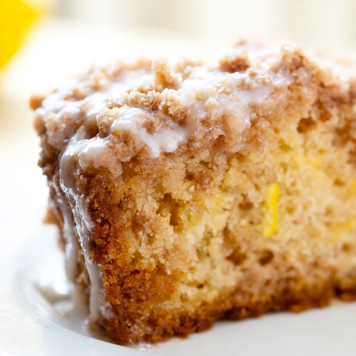 Bright slice of Lemon Coffee Cake with Cinnamon Crumble on a plate with fresh berries for brunch.