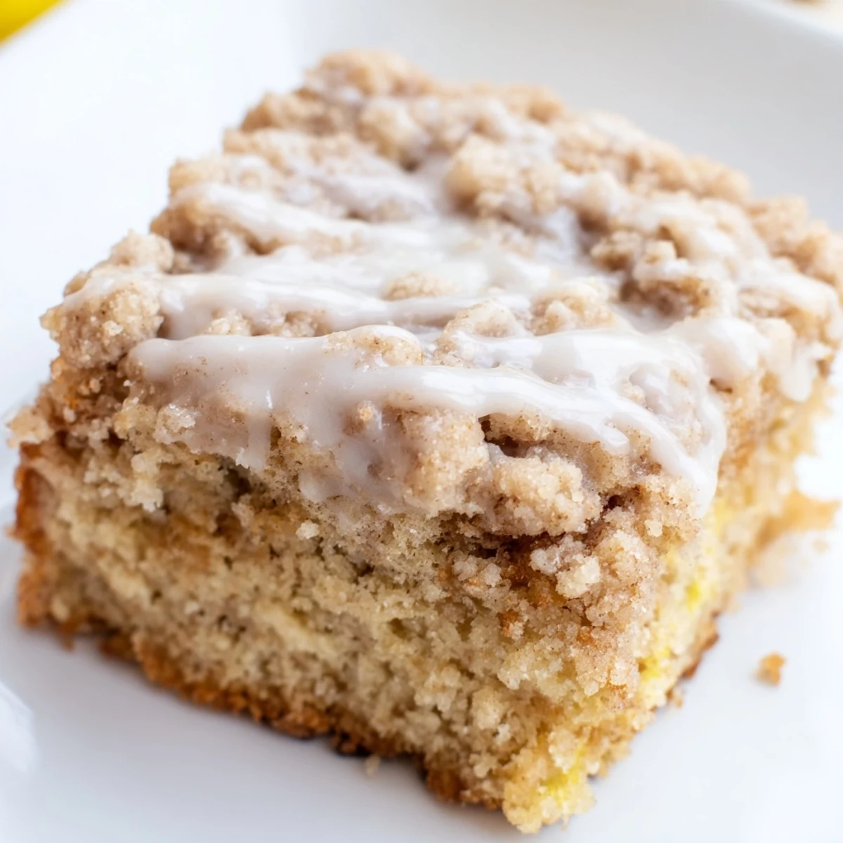 Homemade Lemon Coffee Cake with Cinnamon Crumble drizzled with glaze, ready to serve for breakfast.