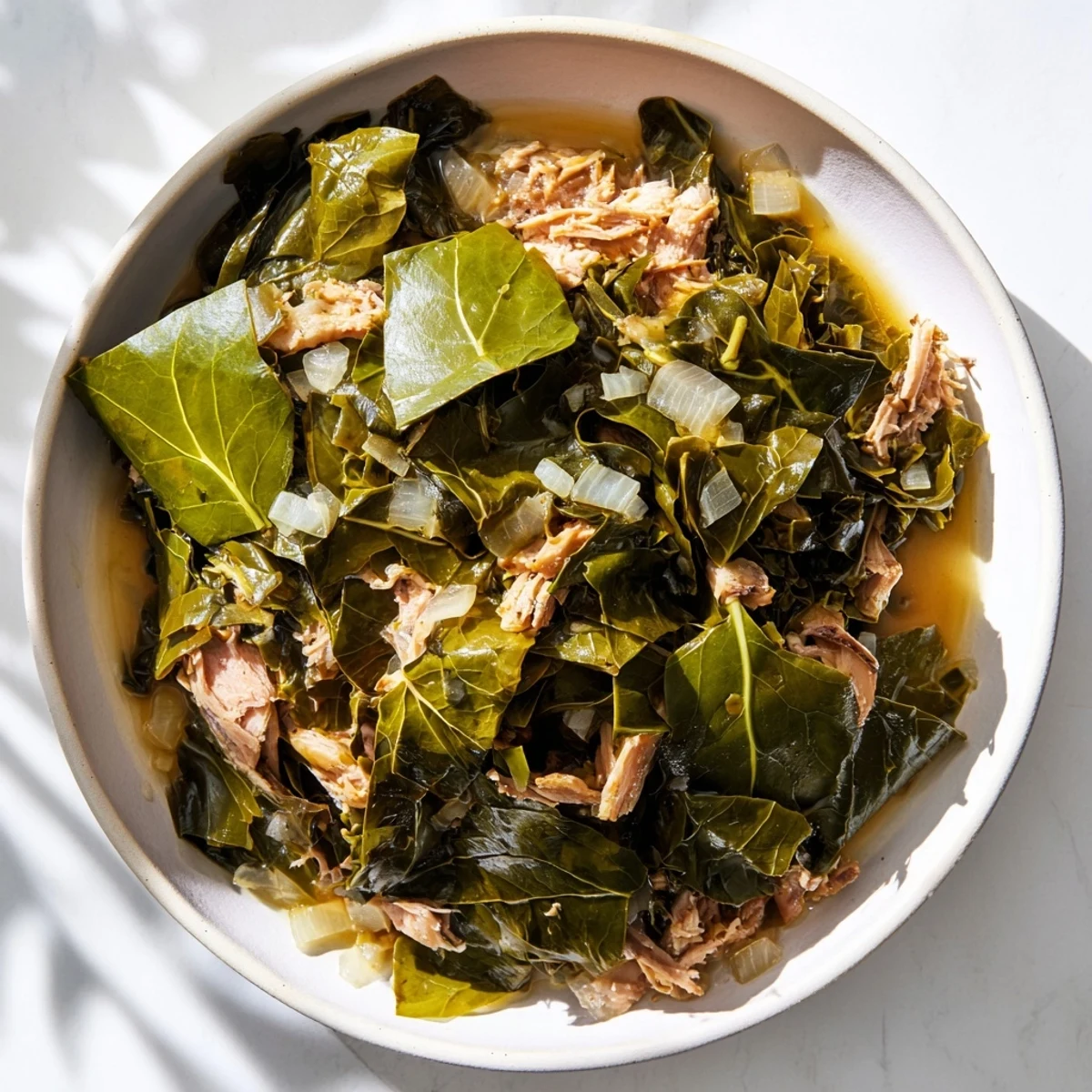 Tender Southern Collard Greens with Smoked Turkey simmered with onions and spices, ready to serve with cornbread.