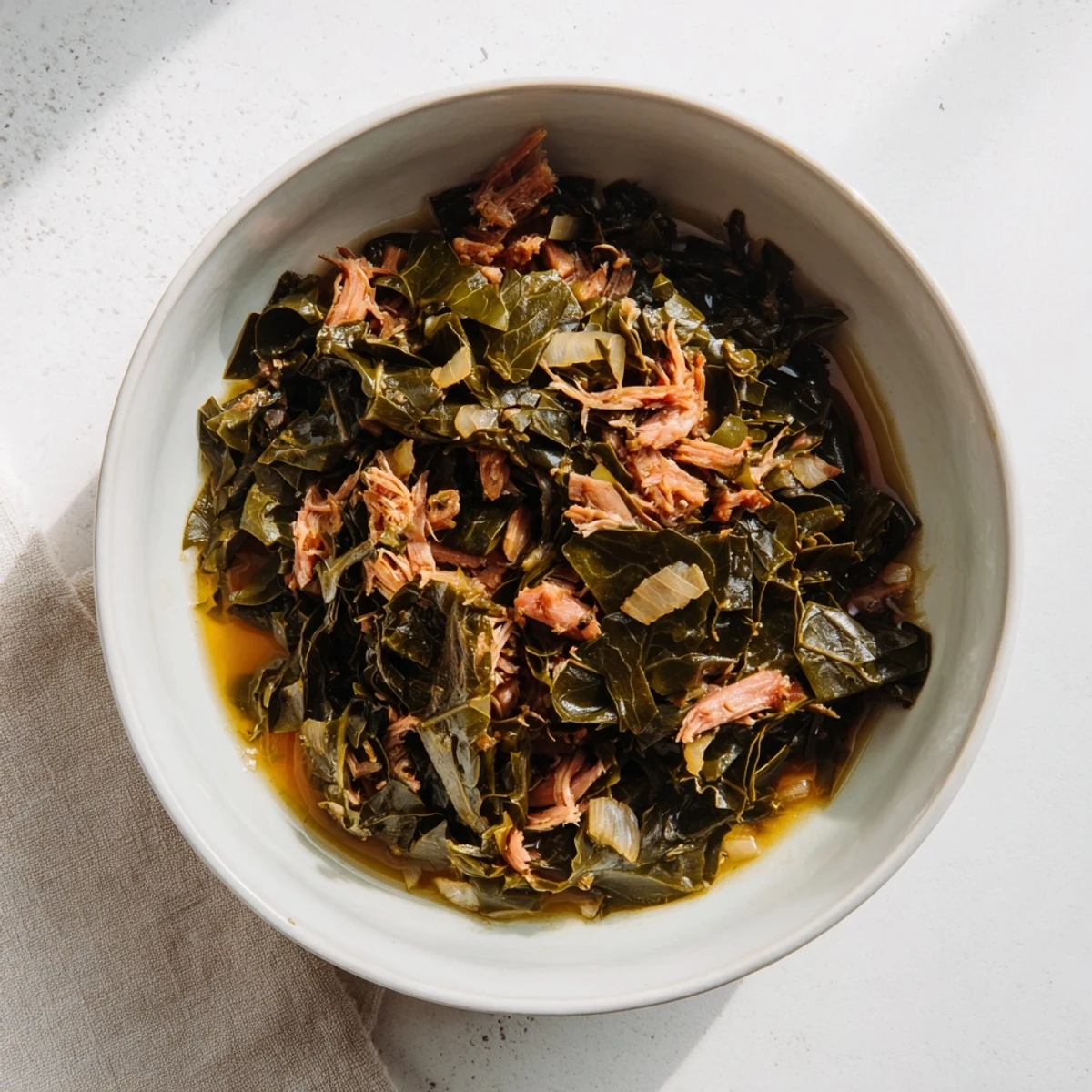 Hearty Southern Collard Greens with Smoked Turkey displayed in a pot, garnished with a splash of cider vinegar.