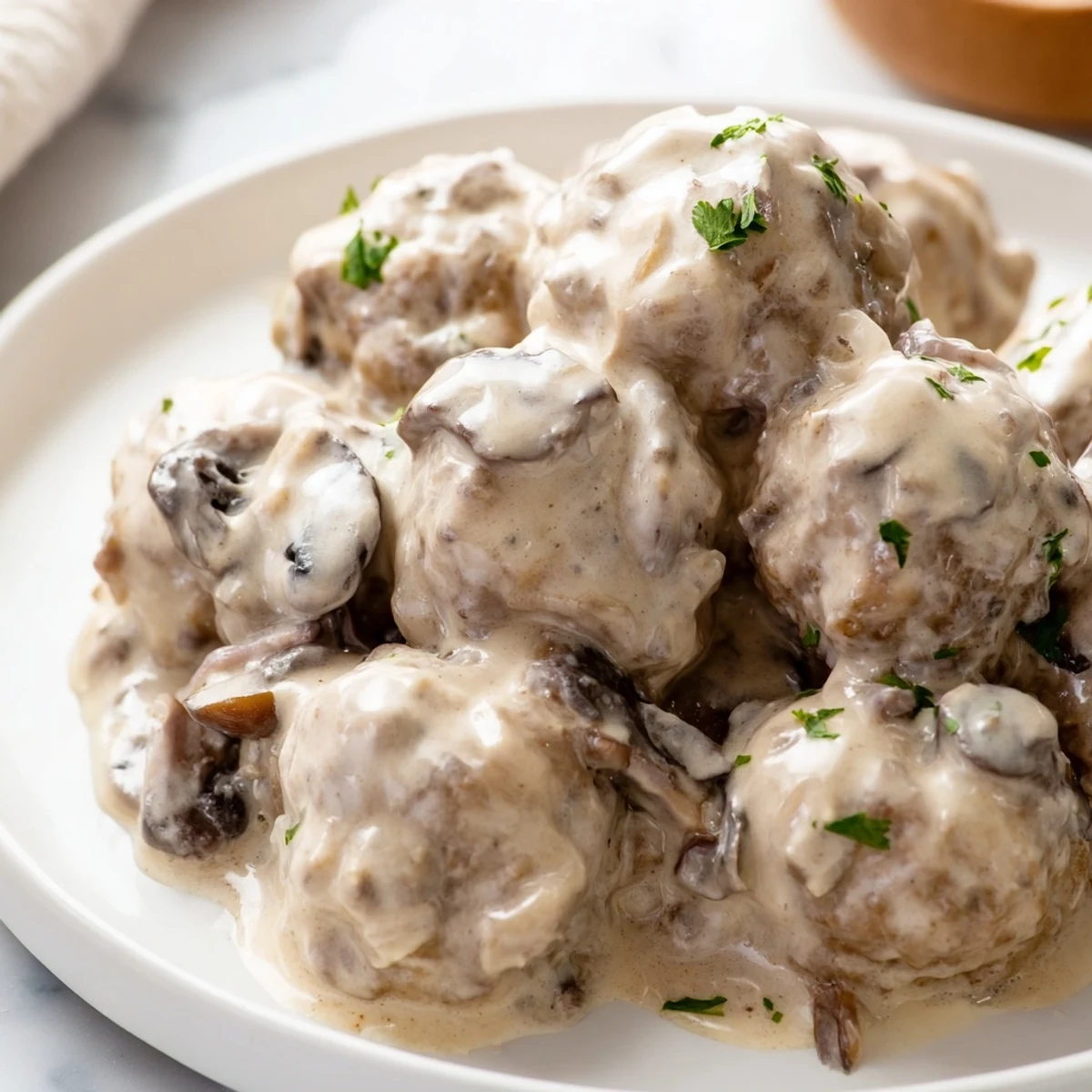 Golden-baked turkey meatballs rest in rich stroganoff sauce, served on fluffy egg noodles with a sprinkle of fresh parsley for color.