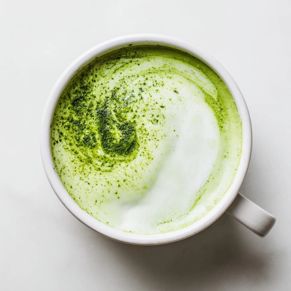 A creamy shamrock green matcha latte sweetened with honey, served steaming in a ceramic mug with a dusting of matcha.