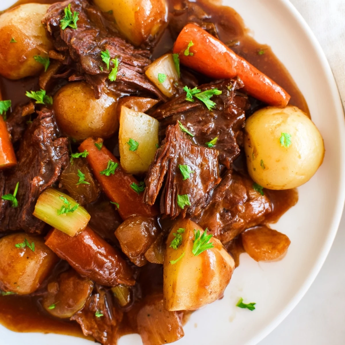 A plated serving of Irish Beef Pot Roast with Root Vegetables, featuring tender shredded beef, carrots, and potatoes with rich gravy.