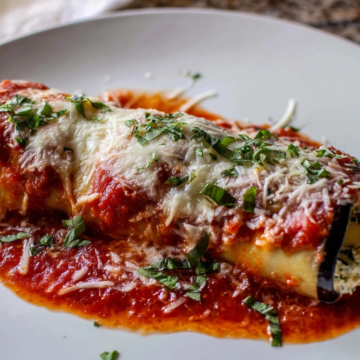 Freshly baked Baked Eggplant Rollatini with Ricotta Cheese, bubbling with marinara and mozzarella, ready for a family dinner.