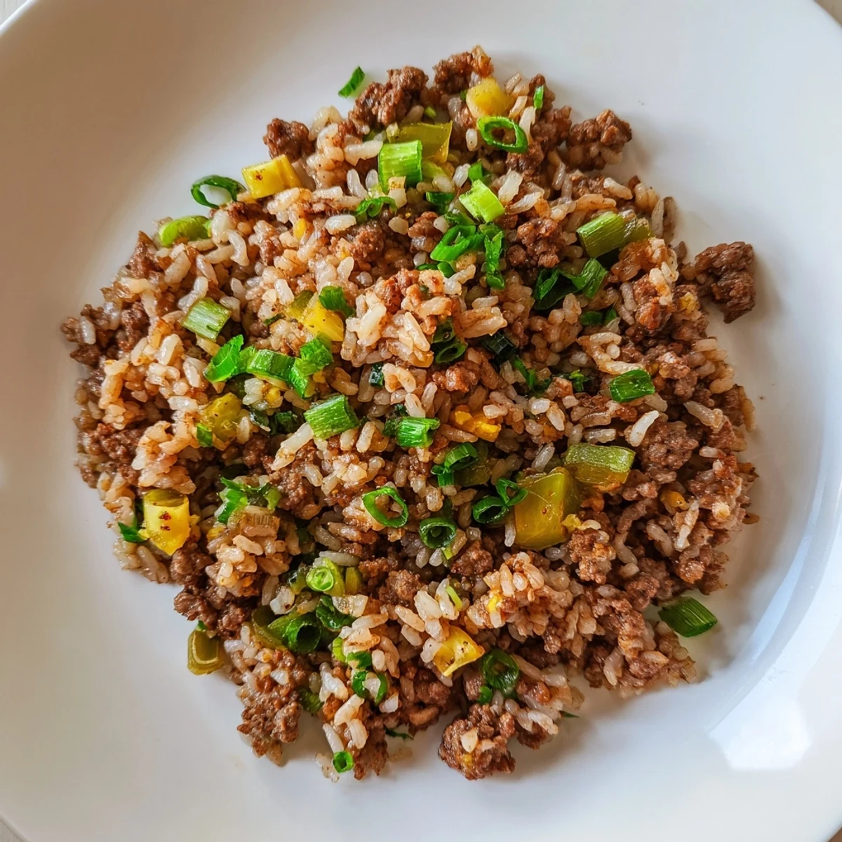 Serving suggestion for Cajun Dirty Rice with Ground Beef and Herbs, plated with a side of crisp green salad.