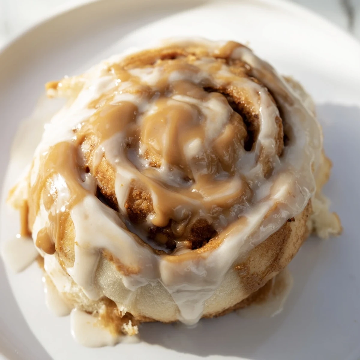 A close-up of Soft and Gooey Biscoff Cinnamon Rolls, glazed and ready to serve.