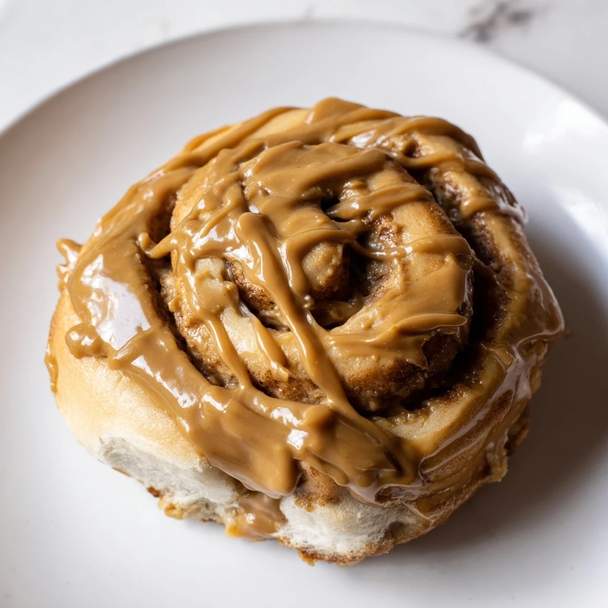 Homemade Soft and Gooey Biscoff Cinnamon Rolls drizzled with creamy glaze for breakfast.