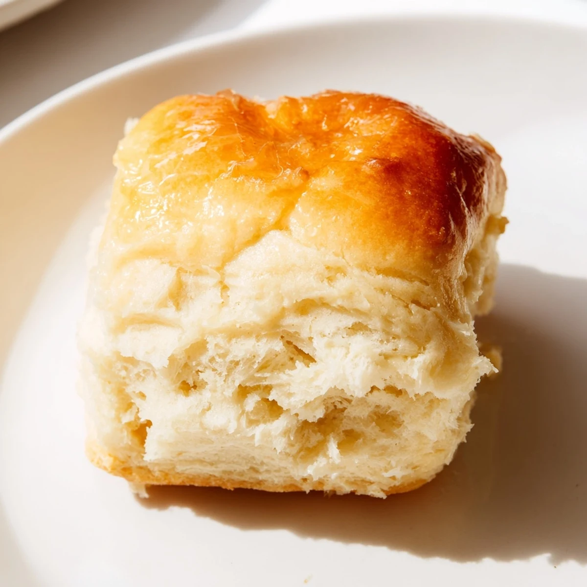 A close-up of Best Vegan Dinner Rolls brushed with vegan butter, perfect alongside a hearty plant-based soup.
