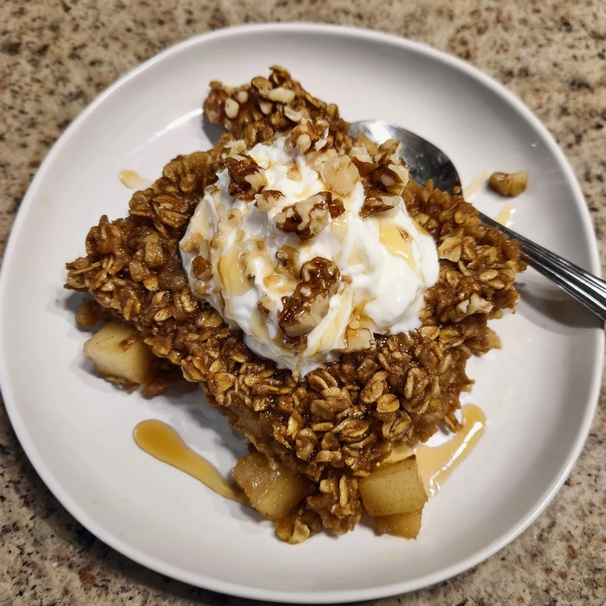 Steaming squares of baked apple oatmeal with Greek yogurt on a rustic board.