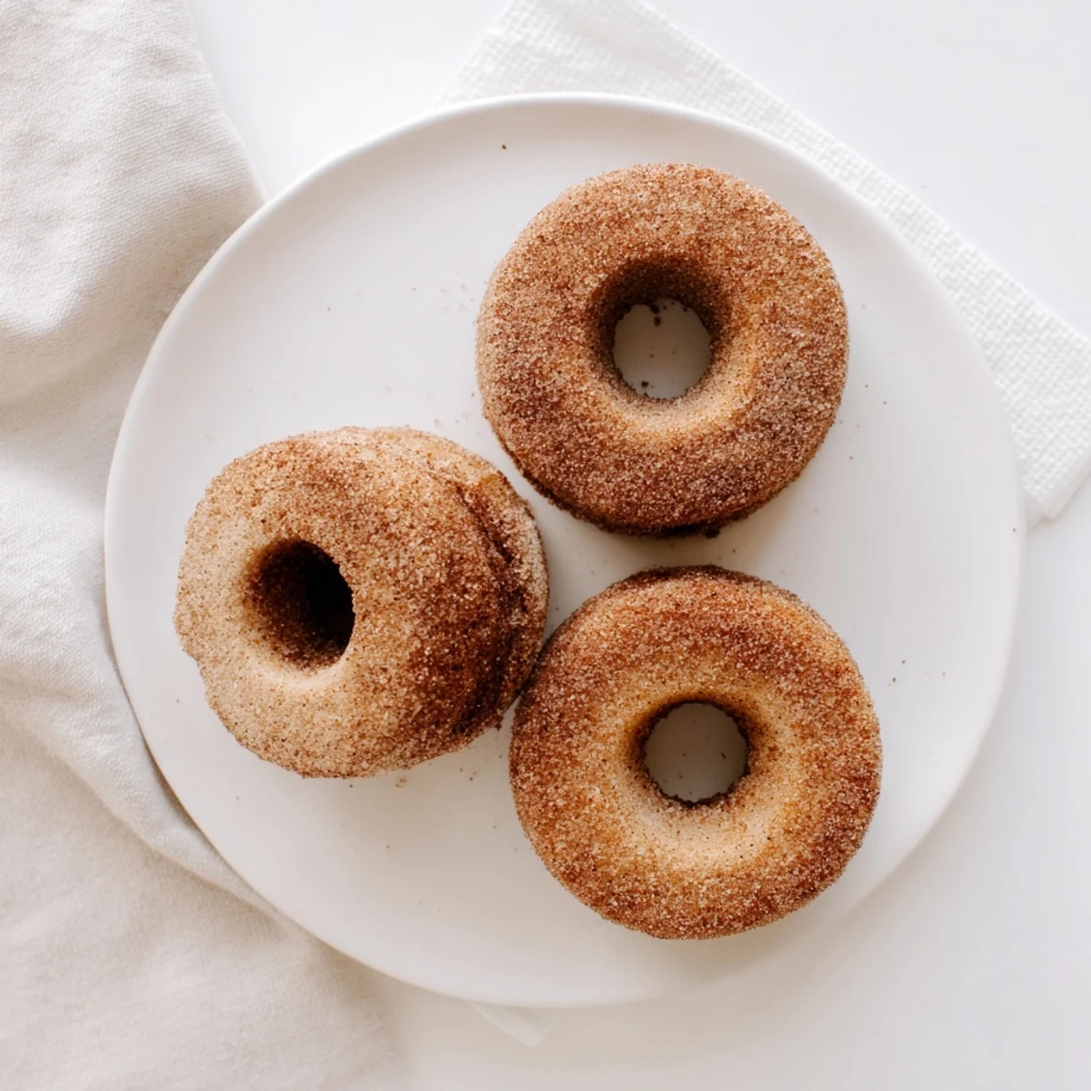Delicious Baked Cinnamon Sugar Donuts you can’t resist, fresh from the oven and resting on a wire rack with a buttery, glistening glaze.
