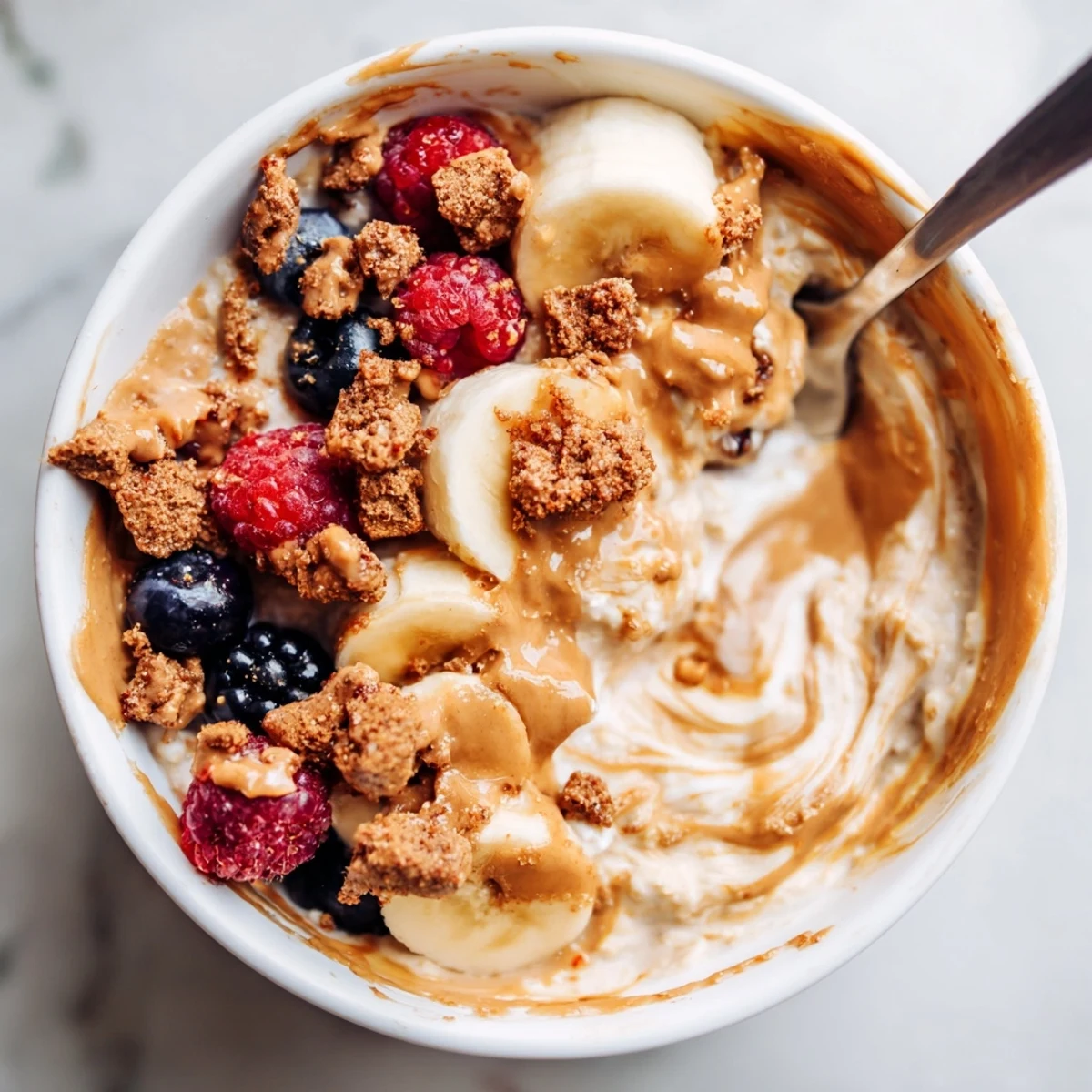 Creamy Biscoff overnight oats topped with crushed cookies and fresh berries, served chilled in a jar.  