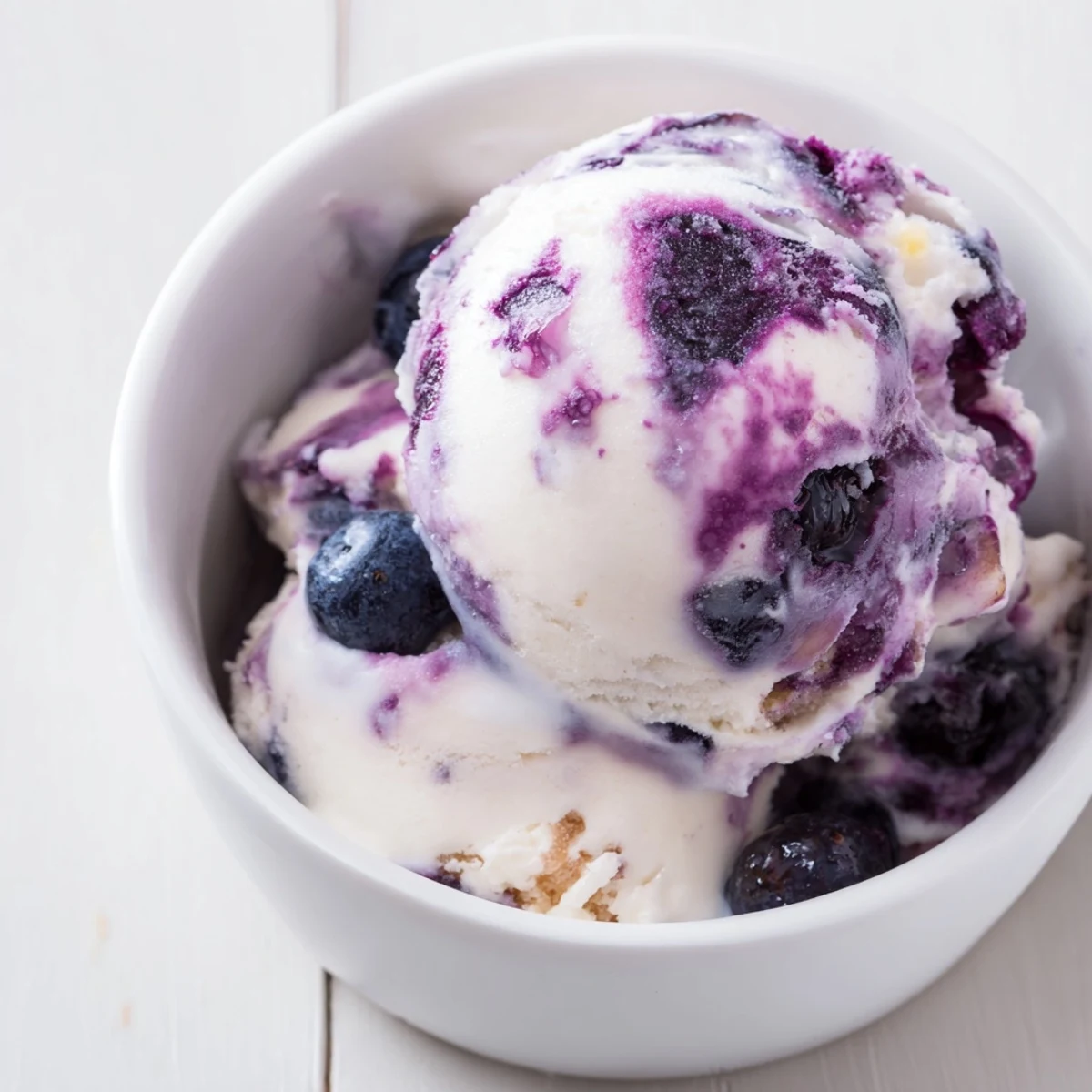 A swirl of Blueberry Cottage Cheese Ice Cream in a freezer container, showing its thick, protein-rich texture.