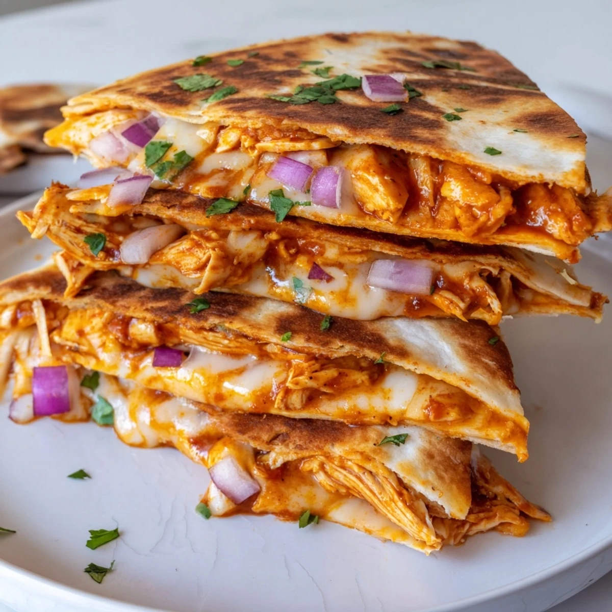 Golden-brown Hot Honey BBQ Chicken Quesadillas on a plate, filled with melty cheese and served with lime wedges and sour cream.