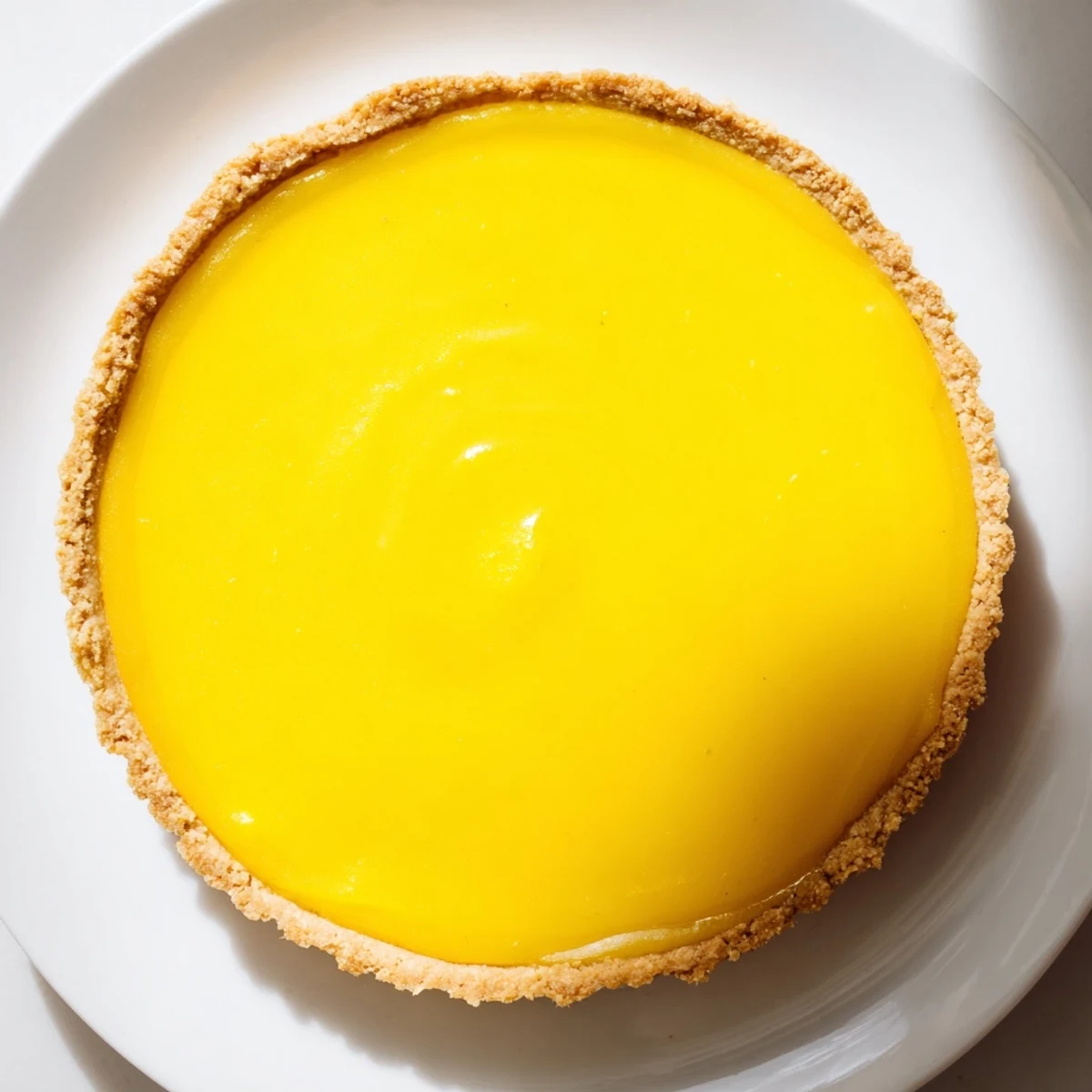 Silky mango curd tart in crisp shell garnished with vibrant fruit for summer dessert