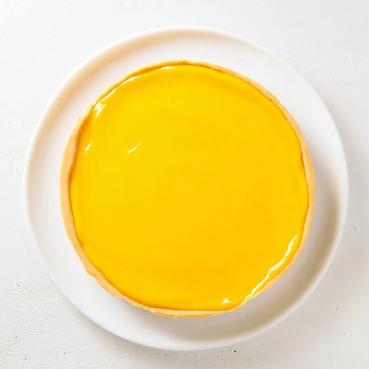 Luscious mango curd tart with smooth filling and golden crust on elegant serving platter