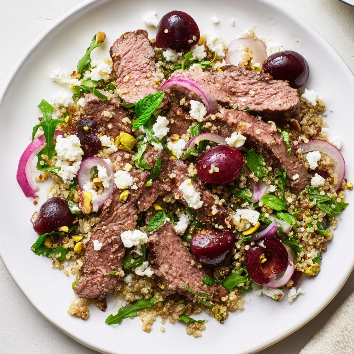 Colorful cherry quinoa salad with lamb showcasing tender meat, fresh cherries, and fluffy quinoa in a vibrant bowl