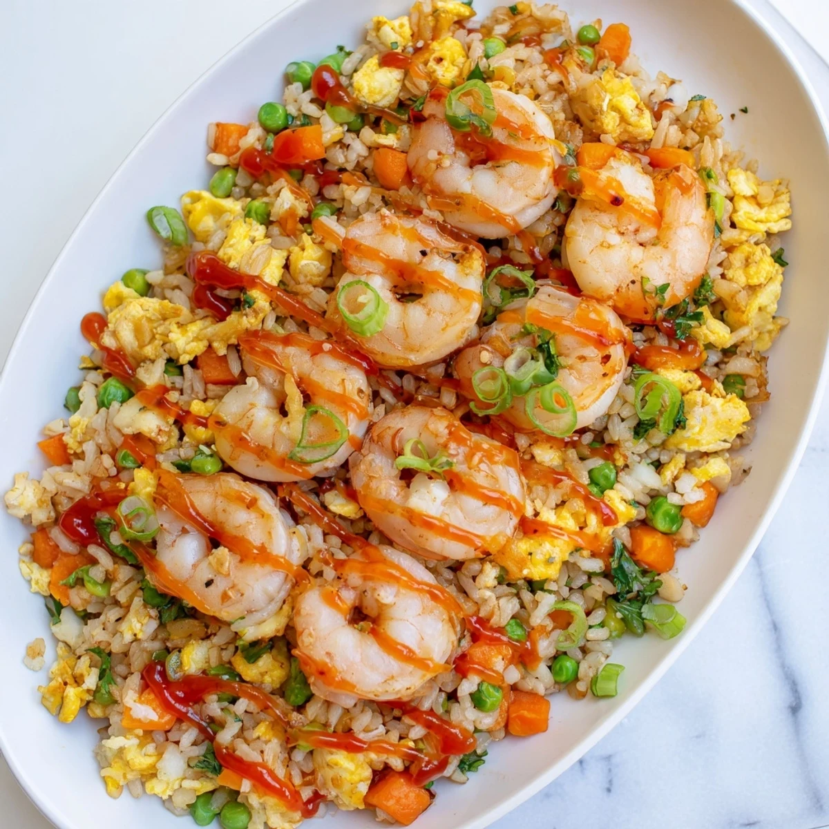 Steaming plate of Asian fusion garlic prawns and sweet chilli fried rice garnished with fresh parsley