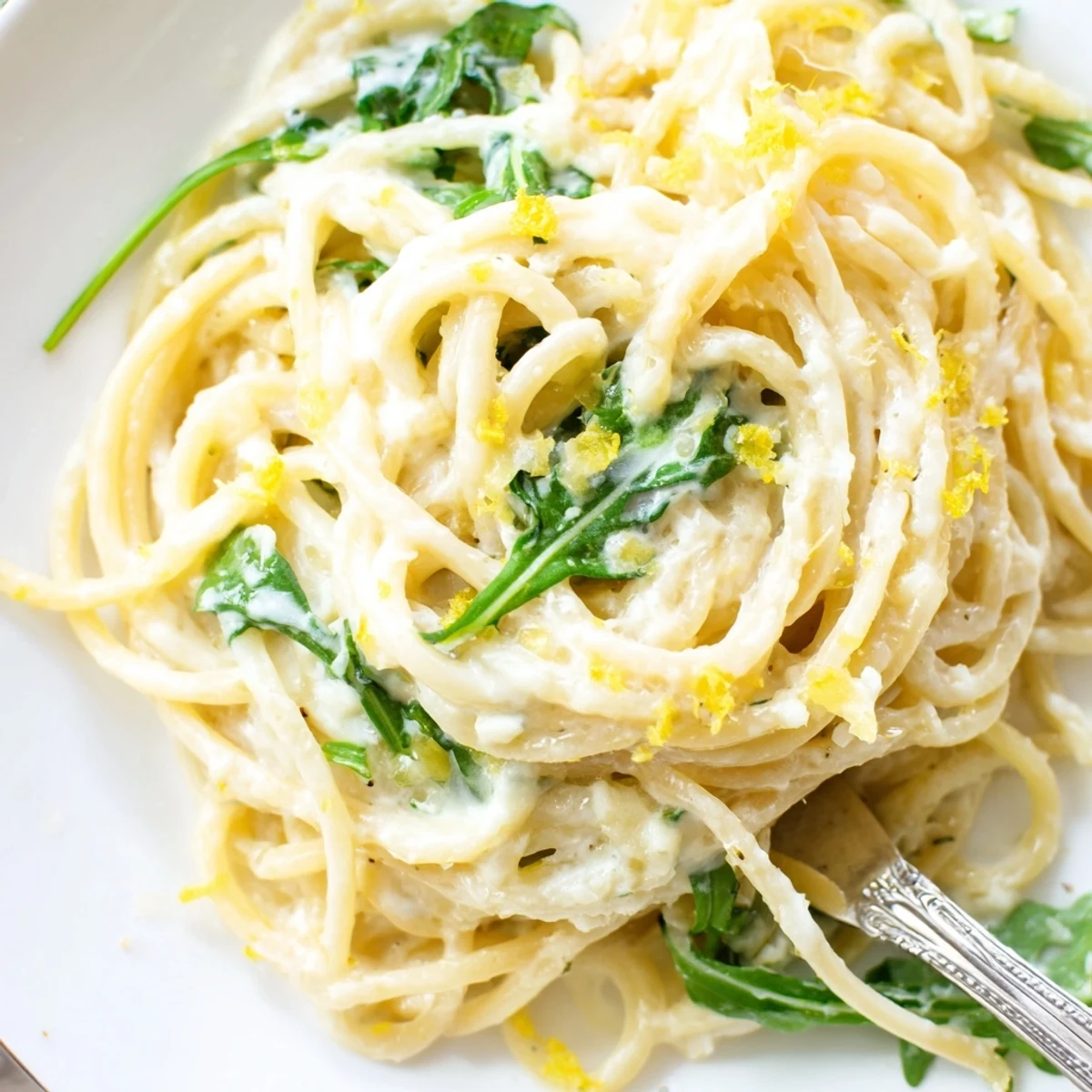 Golden linguine coated in tangy lemon ricotta sauce topped with peppery arugula leaves
