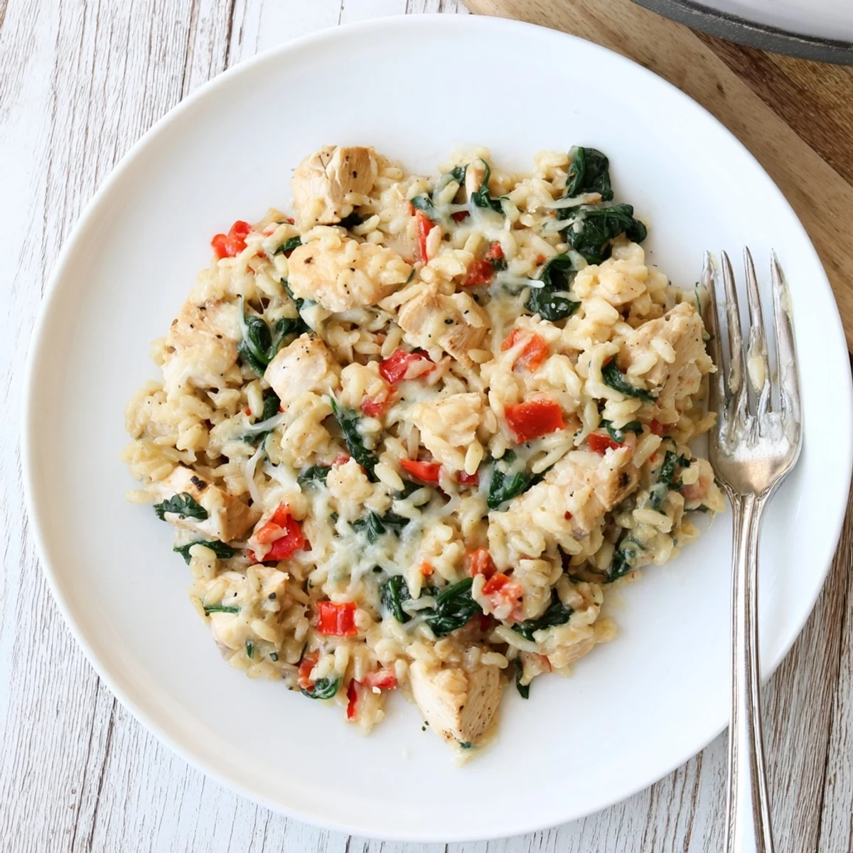 Golden brown chicken pieces in a rich cheesy risoni pasta with fresh spinach garnish