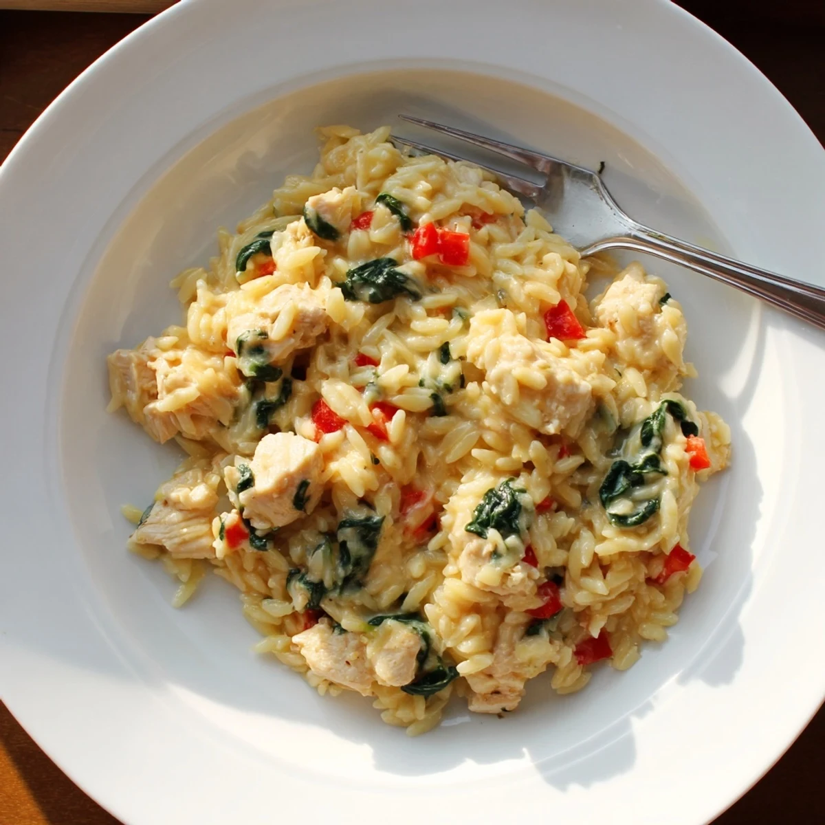 Heating skillet showing thirty minute cheesy chicken risoni bubbling with parmesan and mozzarella