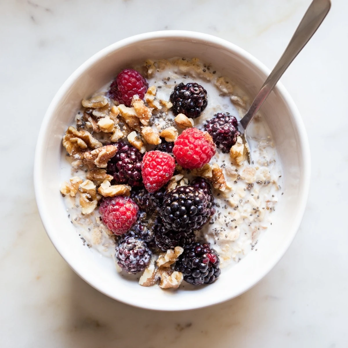Creamy brown sugar overnight oats topped with fresh berries and chopped nuts in a glass jar