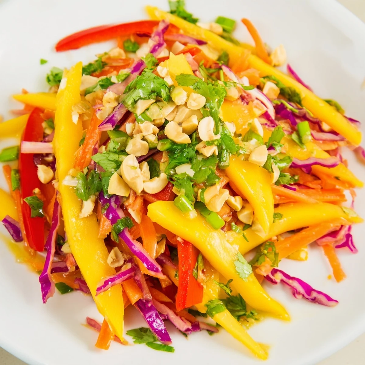 Fresh mango slaw featuring juicy fruit strips, vibrant red cabbage, and crunchy vegetables topped with cilantro