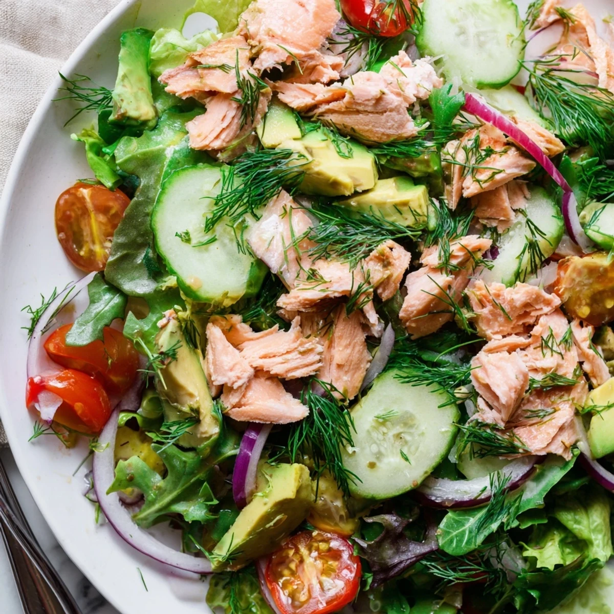 Vibrant minute salmon salad bowl topped with fresh dill and lemon wedges