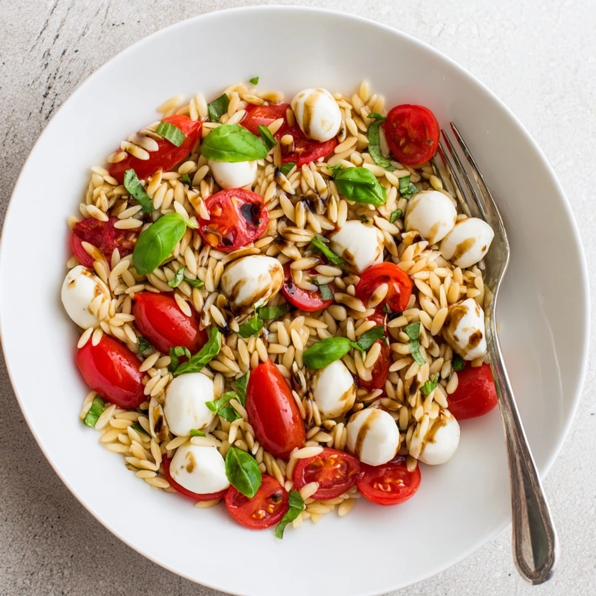 Fresh Caprese orzo pasta salad with cherry tomatoes and mozzarella in balsamic vinaigrette