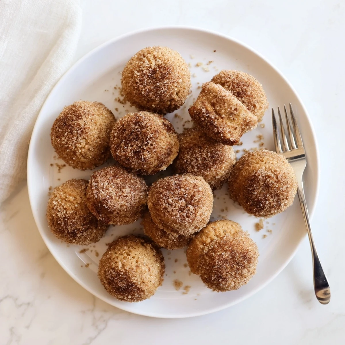Close up of tender easy cinnamon sugar mini muffins piled on serving plate