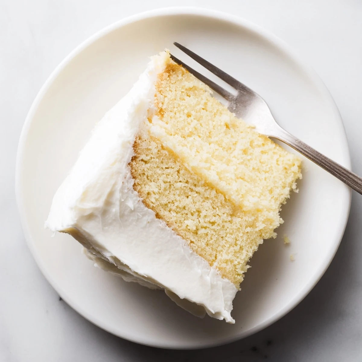 Golden church cake topped with creamy buttercream frosting, dusted with powdered sugar on a serving platter