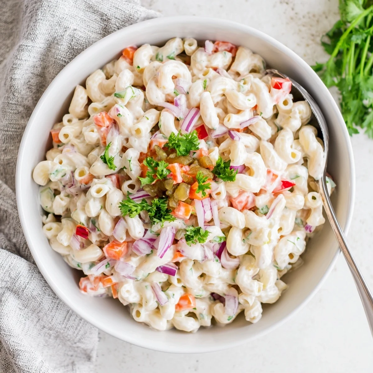 Tangy and creamy macaroni salad served chilled with crunchy red peppers and celery