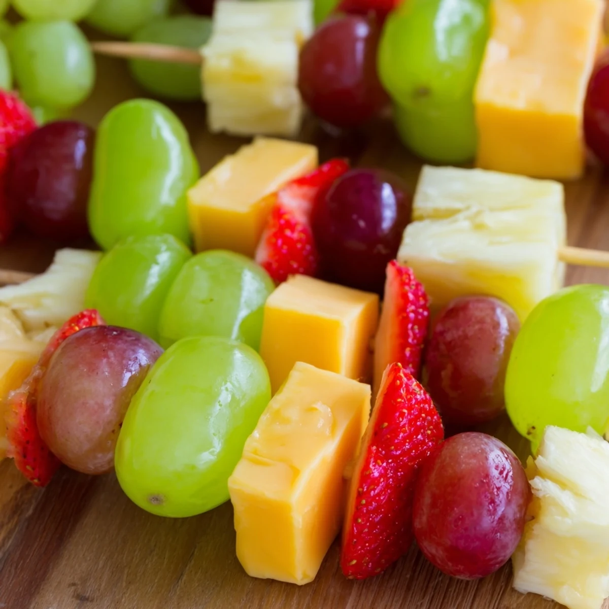 Colorful fruit and cheese kabobs featuring alternating red grapes, pineapple chunks, and creamy Monterey Jack squares