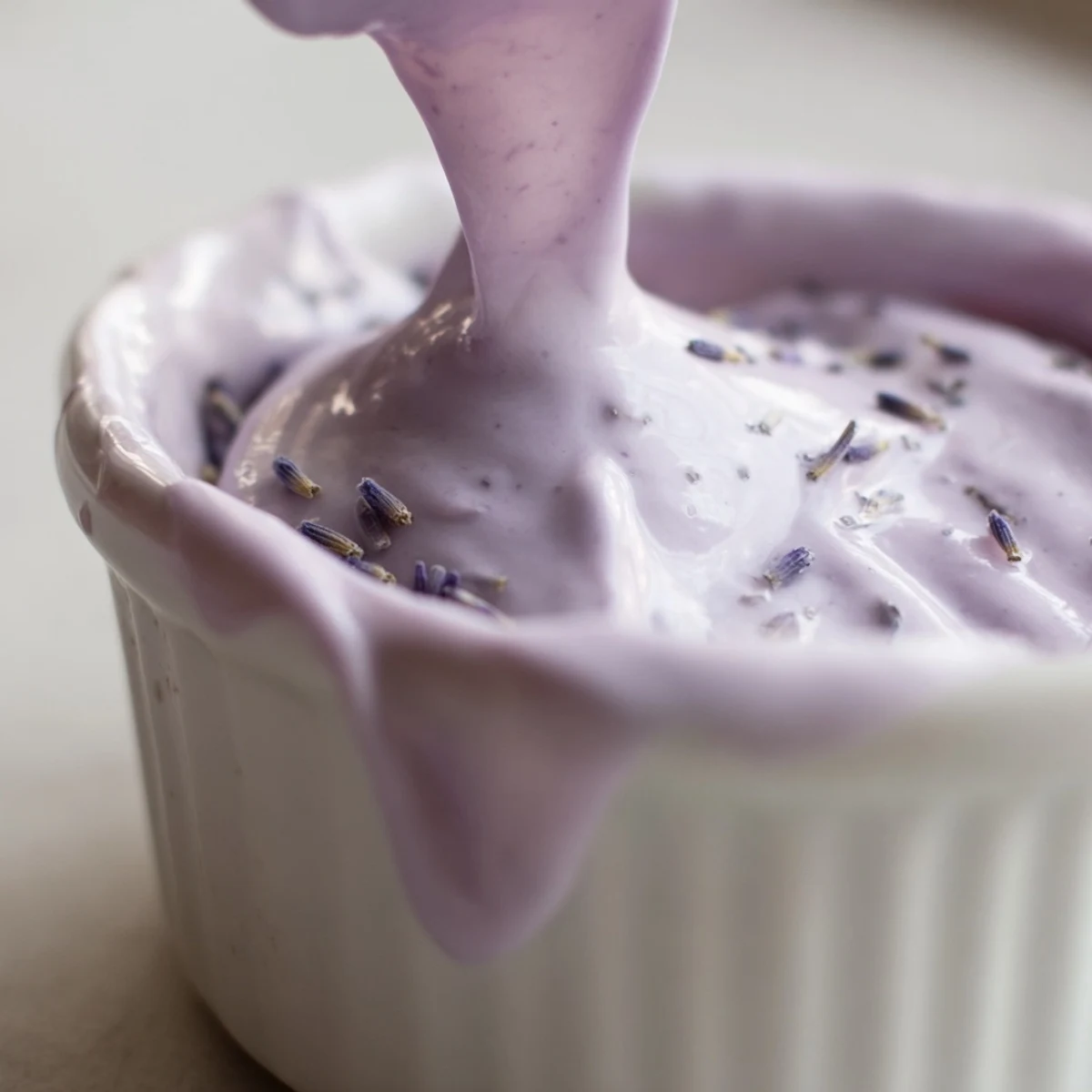 Smooth lavender glaze cascades over a vanilla bundt cake with elegant purple drips
