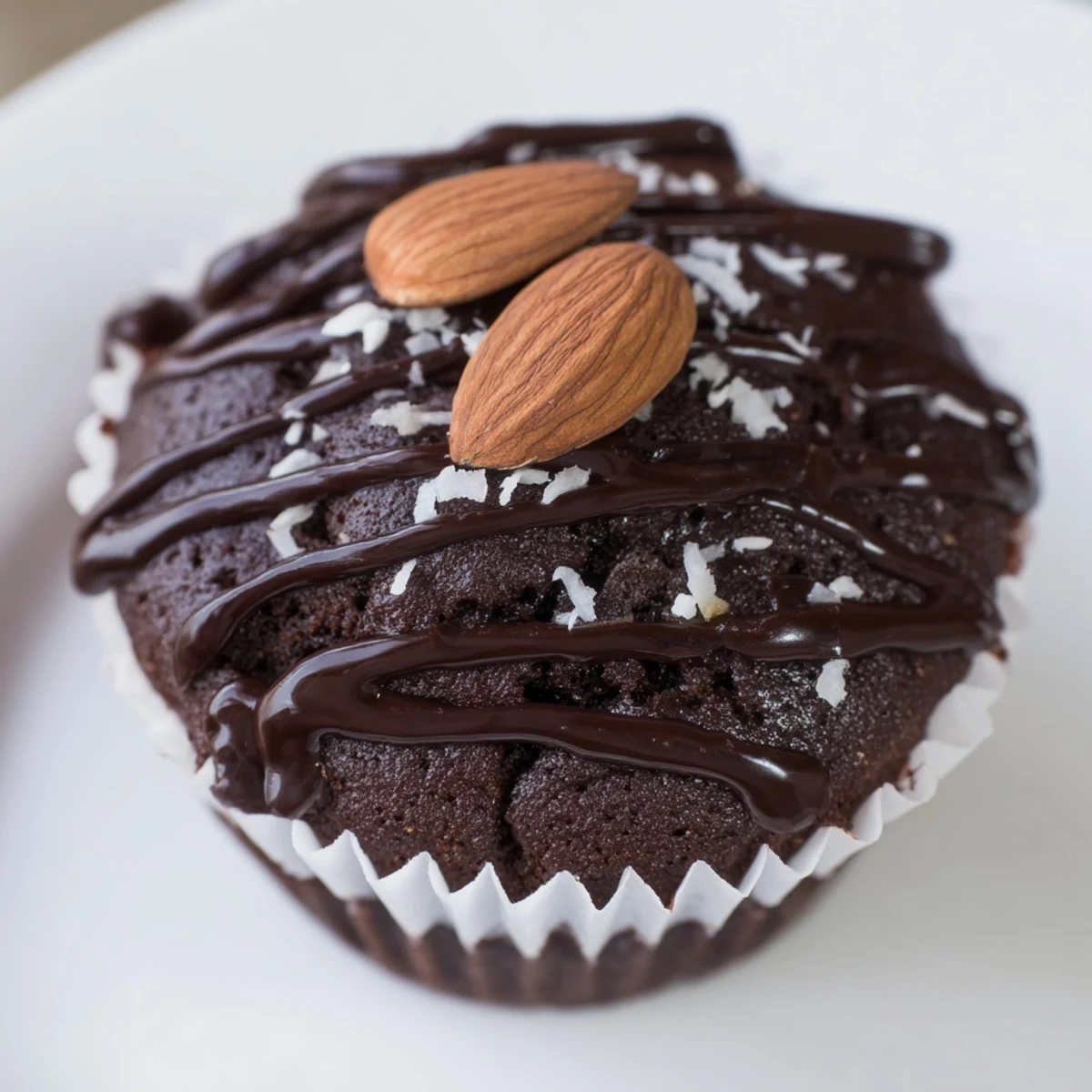 Rich flourless almond joy cupcakes drizzled with melted chocolate and topped with roasted almonds