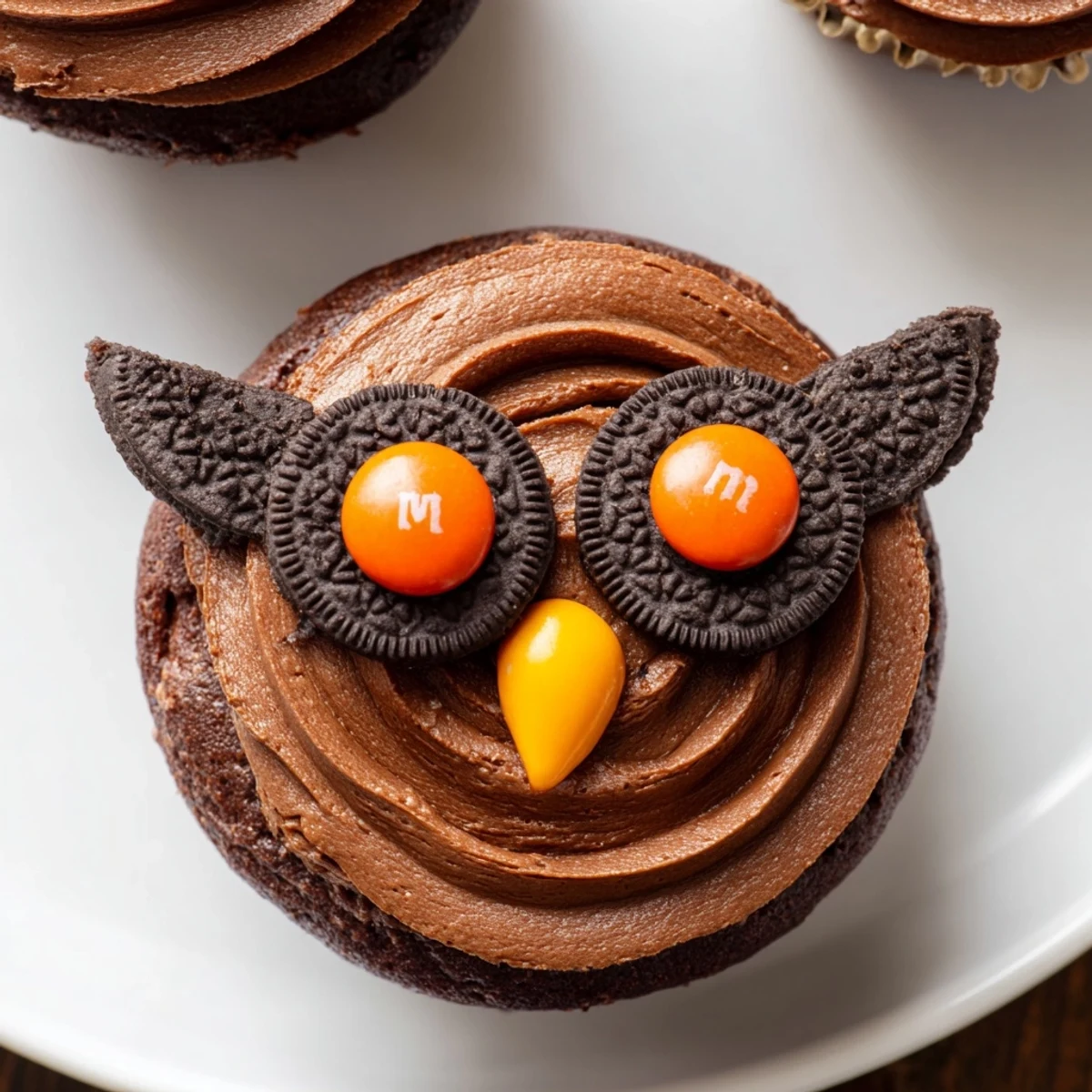 Charming Oreo Owl Cupcakes topped with chocolate frosting and candy eyes on a rustic serving board