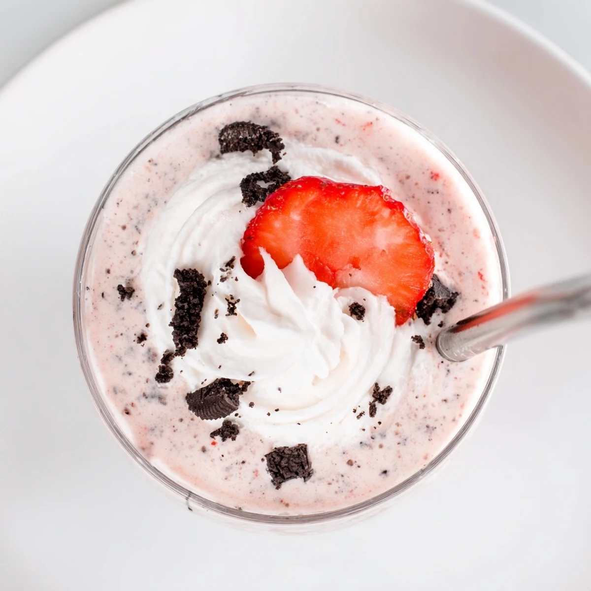 Rich blended strawberry Oreo milkshake garnished with whipped cream and cookie crumbs