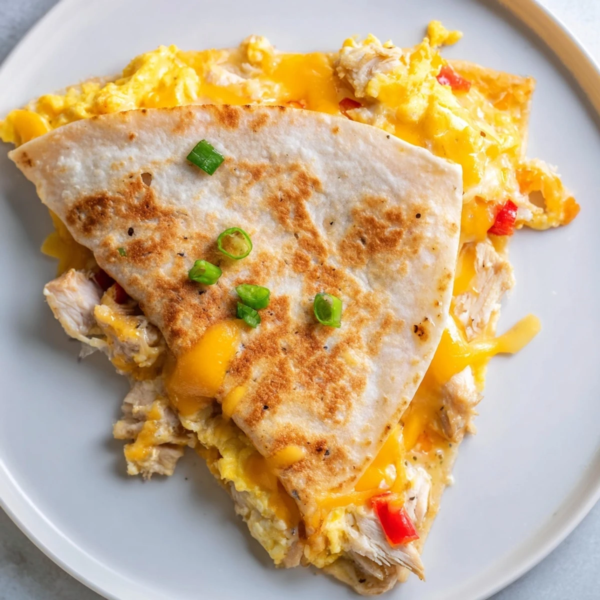 Stacked Chicken Breakfast Quesadilla sliced into wedges, steam rising, avocado optional.