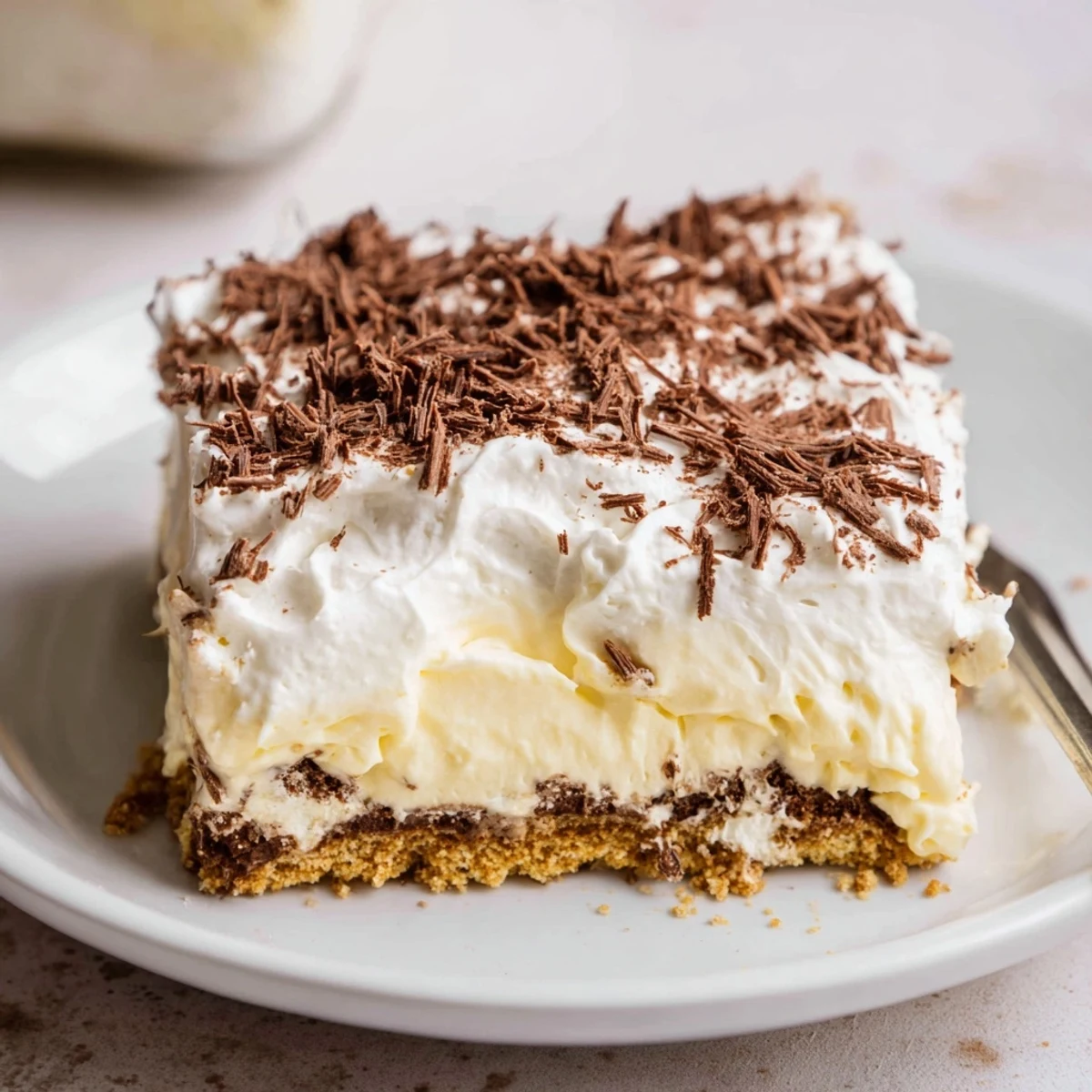 Chilled No Bake Layered Dessert topped with chocolate shavings, ready to slice