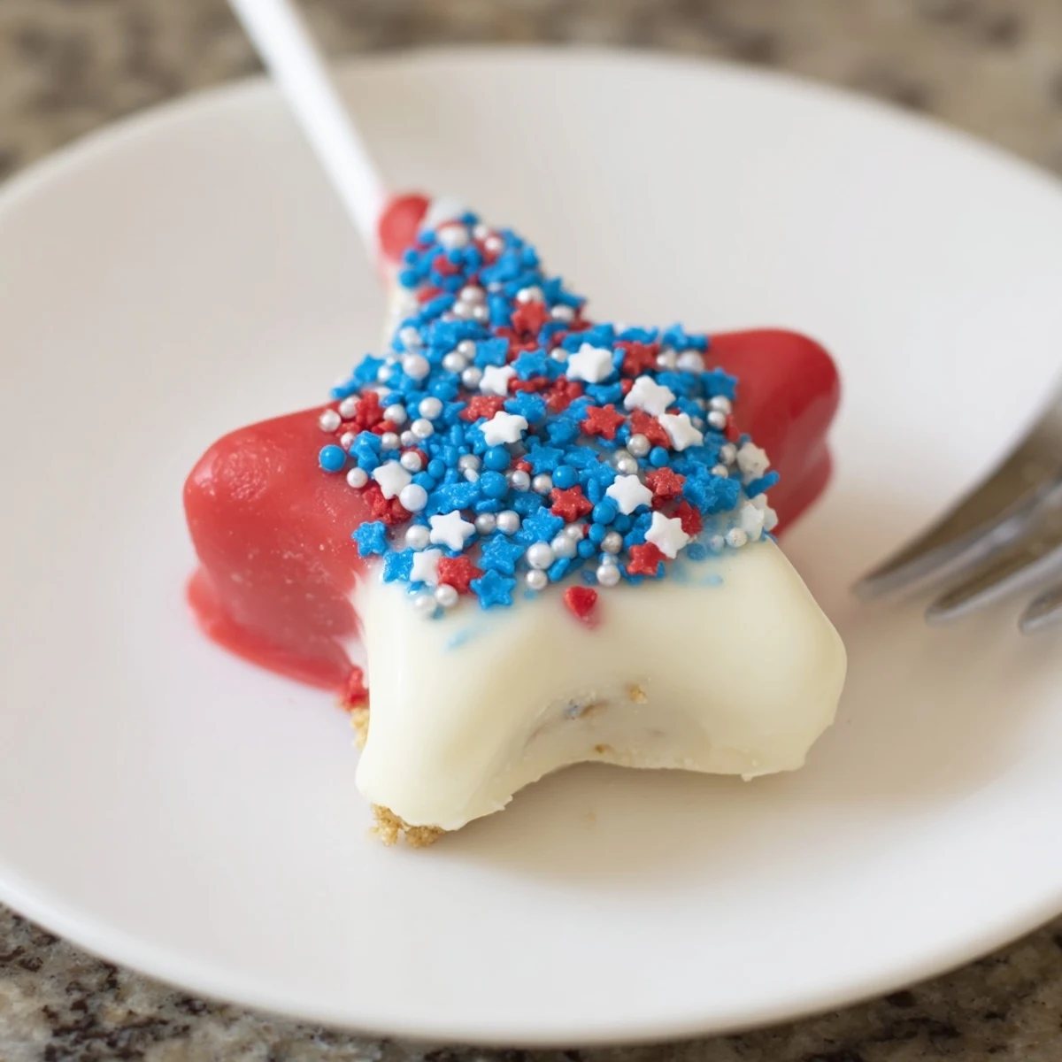 Fourth Of July Star Cheesecake Pops on a tray, glossy chocolate and sprinkles