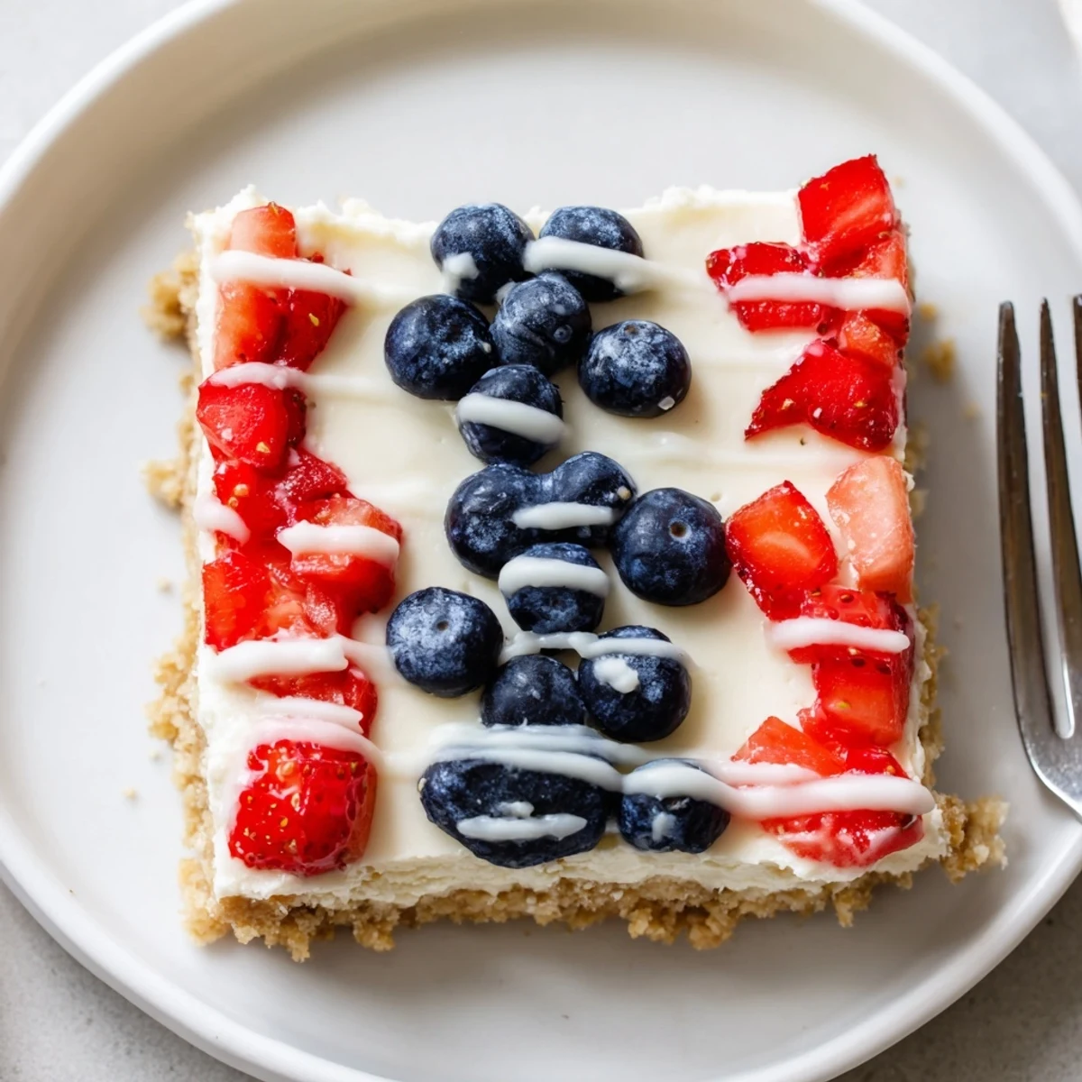 Patriotic Cheesecake Bars topped with juicy strawberries and blueberries, chilled and creamy