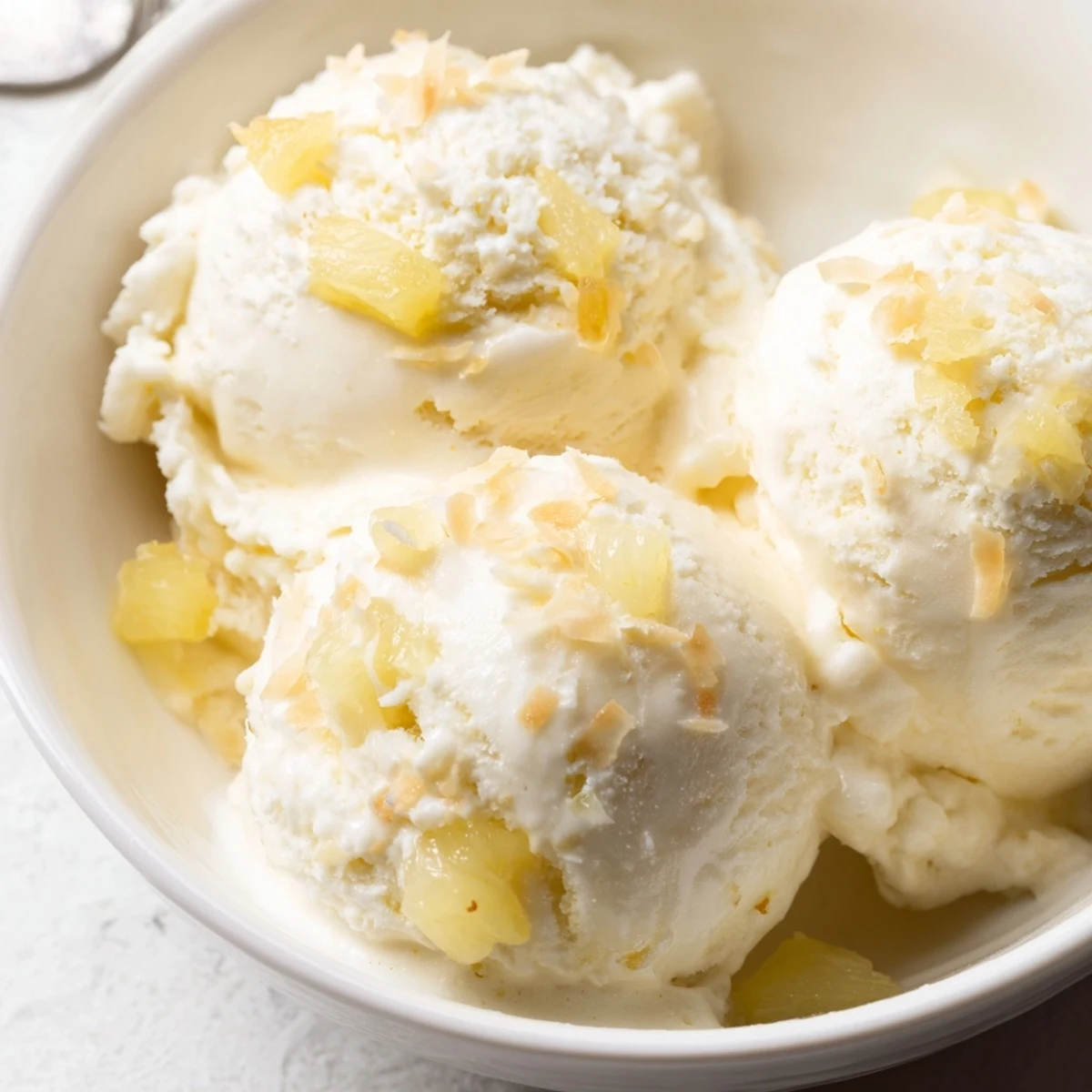 Creamy Pineapple Ice Cream scoops in a chilled bowl, tropical tanginess  