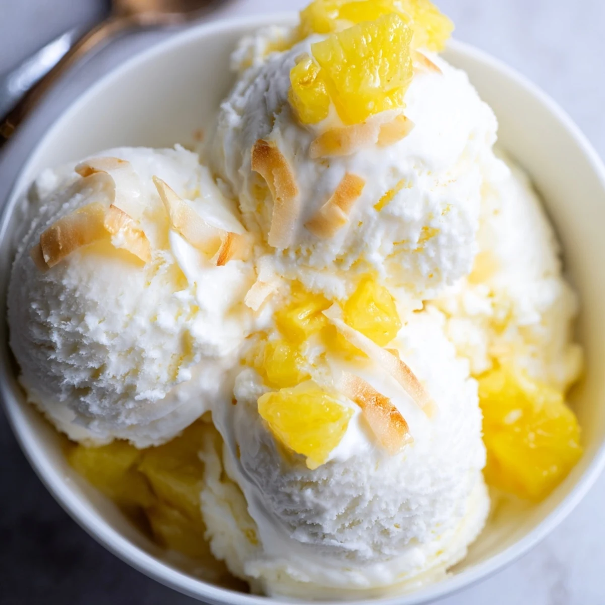 Homemade Creamy Pineapple Ice Cream churned silky-smooth, topped with toasted coconut  