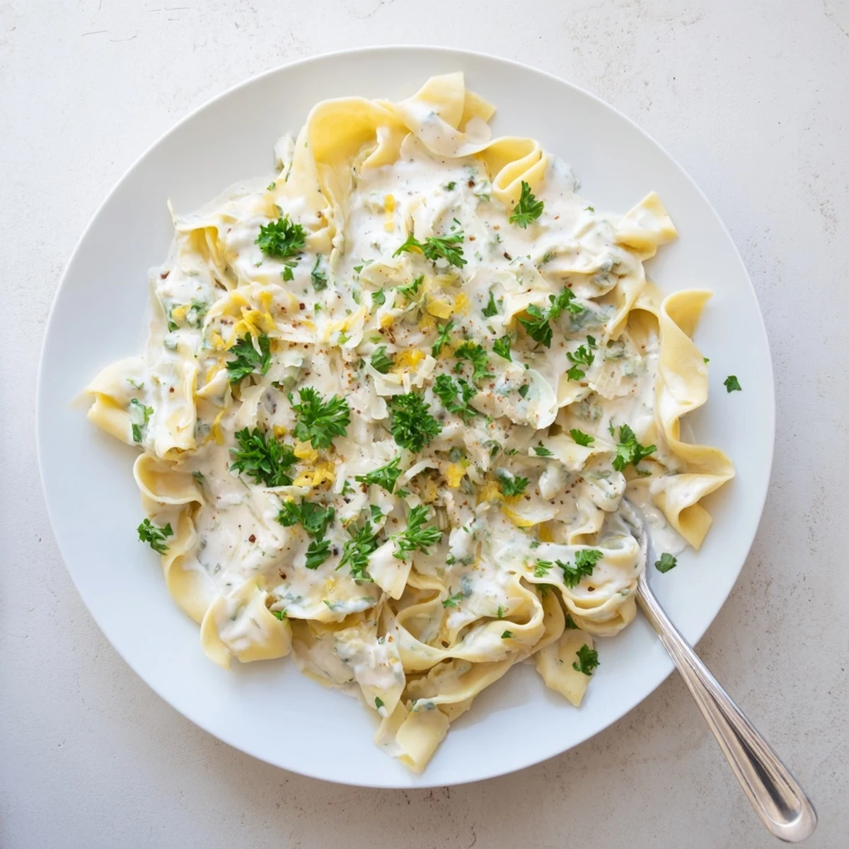 Comforting cafeteria noodles swimming in a savory white cheese sauce with melted Parmesan on top