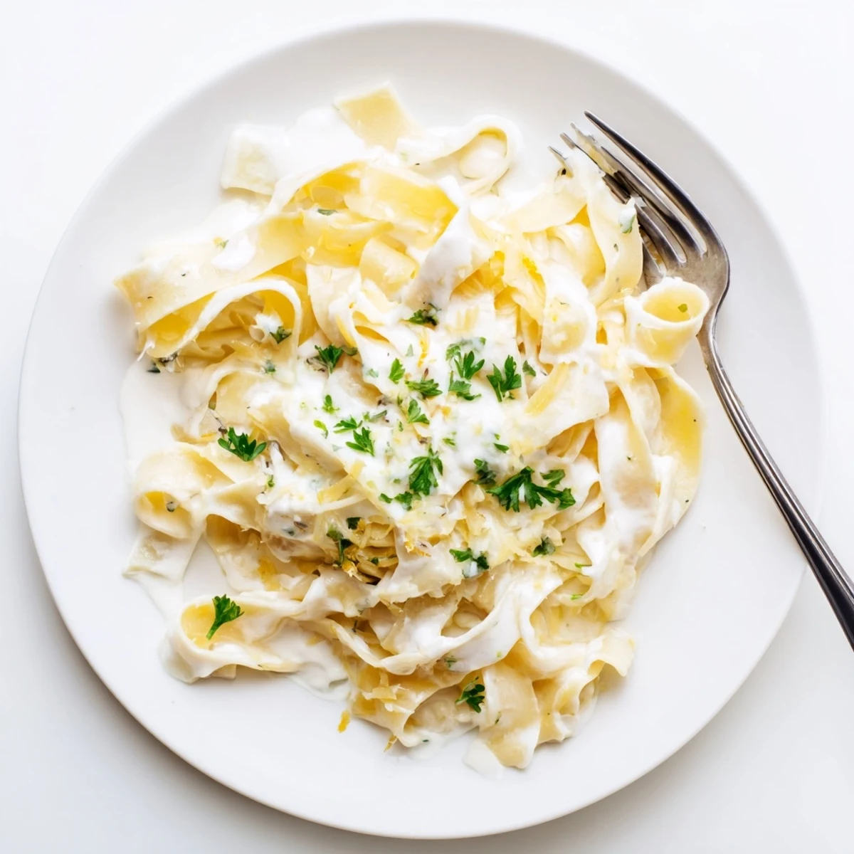 Creamy egg noodle dish featuring tender pasta in a thick velvety sauce with chopped green parsley