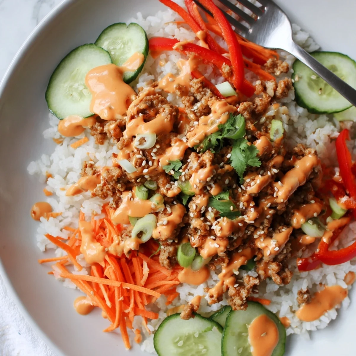 Ground Turkey Rice Bowls drizzled with creamy spicy Bang Bang sauce and crisp vegetables