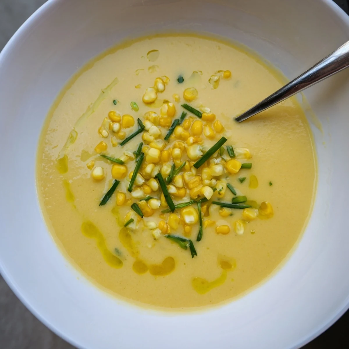 Creamy golden Summer Sweet Corn Gazpacho served cold with chopped chives and colorful vegetable toppings