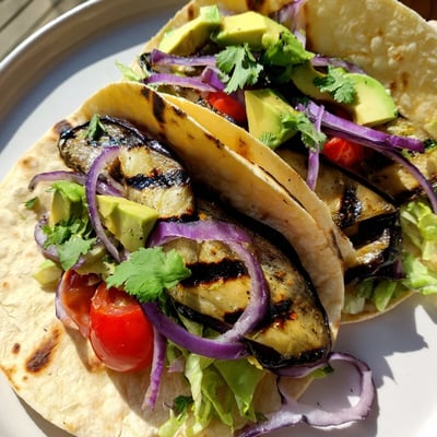 Charred Eggplant Tacos displayed with vibrant toppings and lime wedges for a zesty finish.