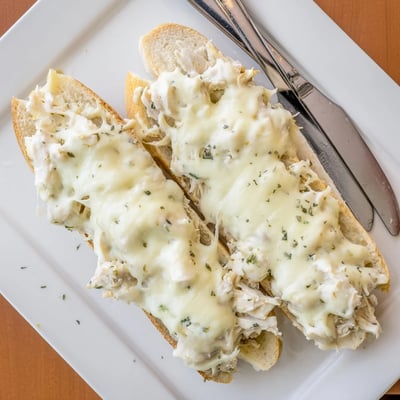 Fresh parsley garnishes this easy Viral Chicken Alfredo Garlic Bread appetizer baked until bubbly and golden.
