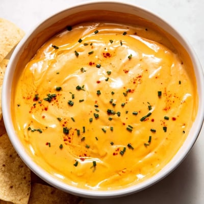 Creamy cheese dip topped with fresh chives, served with crisp veggie sticks.